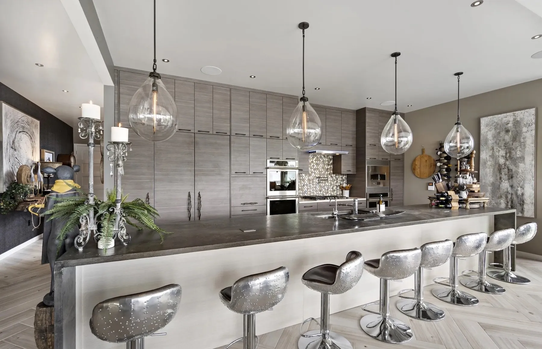 Long concrete kitchen island with waterfall ends and a row of bar stools