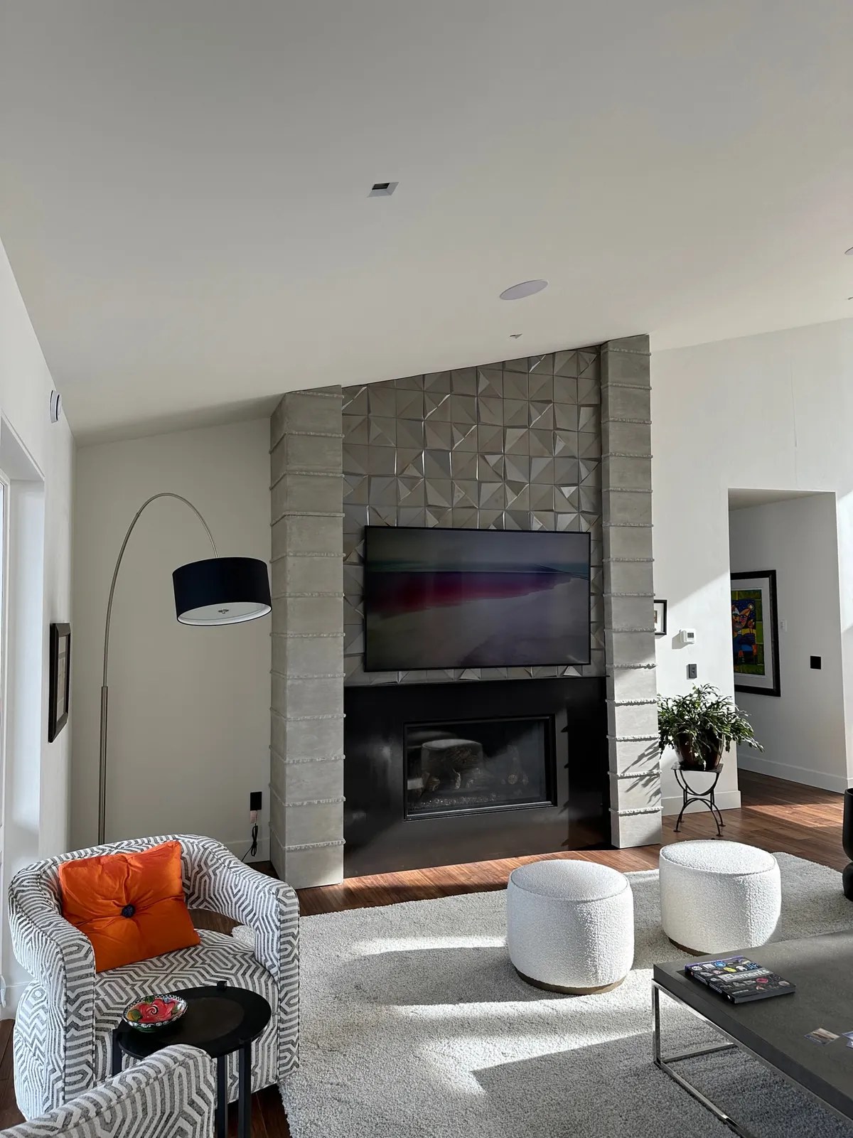 Textured concrete columns framing a fireplace and TV wall in a bright living room